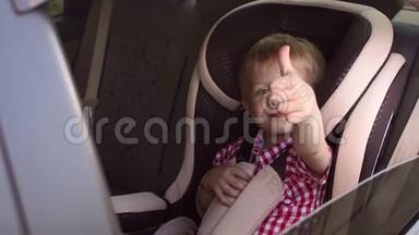 一个快乐的小男孩坐在<strong>棕色</strong>的儿童汽车<strong>座椅</strong>上，竖起大拇指。